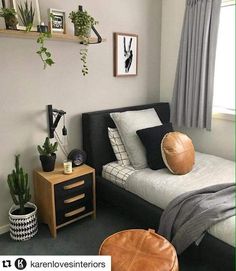 a bed room with a neatly made bed and some plants