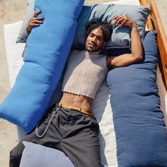 a man laying on top of two blue pillows