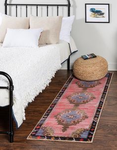 a bedroom with a bed, rug and pictures on the wall