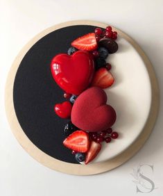 a plate topped with strawberries, berries and heart shapes