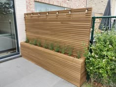 a large wooden planter on the side of a building