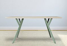 a white table sitting on top of a carpeted floor in front of a wall