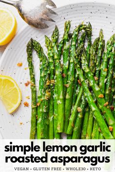 asparagus on a plate with lemon wedges next to it and the title overlay reads, simple lemon garlic roasted asparagus