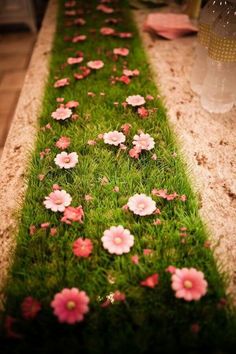 the grass is lined up with pink flowers