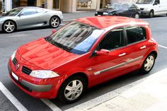 a red car is parked on the street