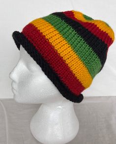 a white mannequin head wearing a multicolored knitted beanie hat