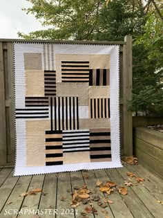 a black and white quilt on a wooden deck