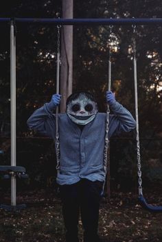 a person wearing a mask on a swing