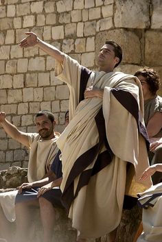 a man dressed as jesus pointing at something in front of him while others look on