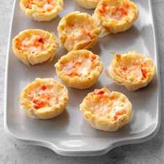 small appetizers are arranged on a white platter and ready to be eaten