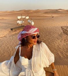 an instagram with a woman wearing a hat and sunglasses in the middle of desert