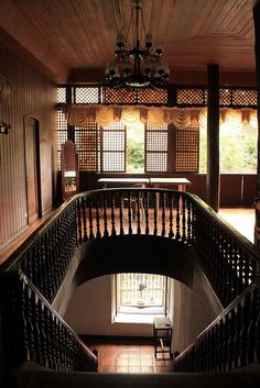 the stairs are made of wood and lead to another room with windows on both sides