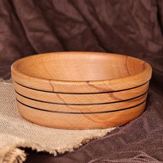 three wooden bowls sitting on top of a brown cloth