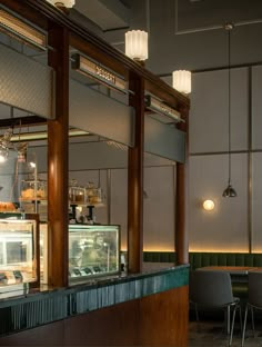 the interior of a restaurant with tables, chairs and food on display in front of it