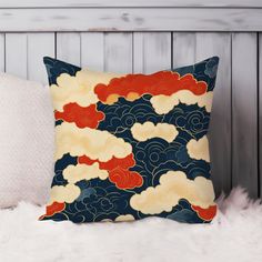 a pillow with clouds on it sitting on top of a white furnishing next to a