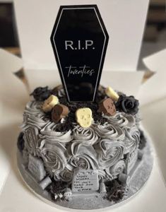 a black and white decorated cake in a box with the name r i p on it