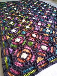 a crocheted blanket on top of a bed