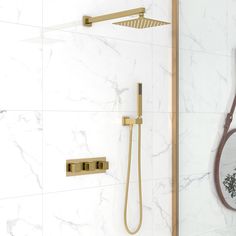 a bathroom with marble walls and flooring, including a gold shower faucet