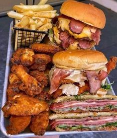 a tray filled with different types of food next to french fries and fried meats