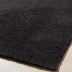 a black area rug on top of a white floor