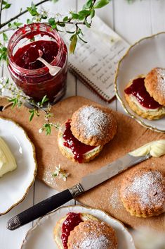 two pastries on plates with jam and butter