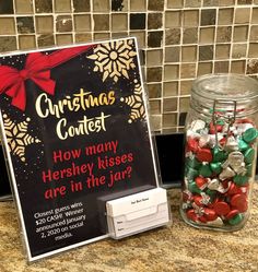 a christmas contest sign and candy in a jar on a granite counter top with tile back splash