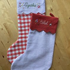 two christmas stockings with embroidered name and gingham checkered stocking on wooden floor