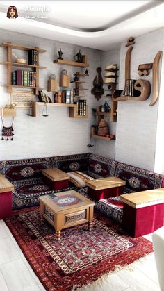 a living room filled with lots of furniture and bookshelves on the wall above