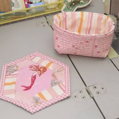 two pink and white baskets sitting on top of a table