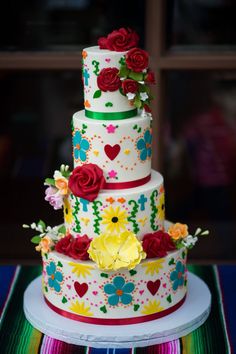 a multi layer cake decorated with flowers and hearts