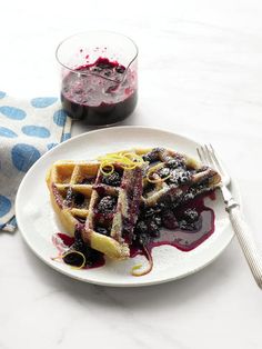 a plate with waffles covered in blueberry sauce