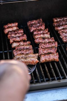 someone is grilling some meat on the grill