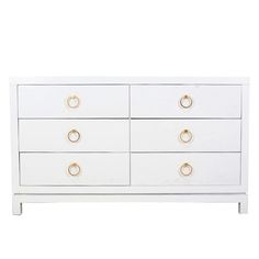 a white dresser with gold handles and knobs