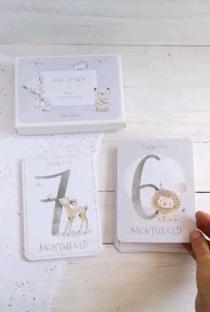 someone is holding up some cards to show the number one and two with animals on them