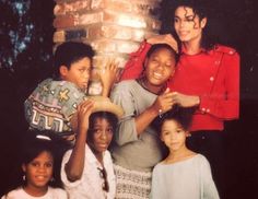 a group of people standing next to each other in front of a brick wall with candles on it