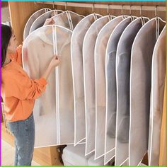 a woman is looking at some clothes hanging on a rack