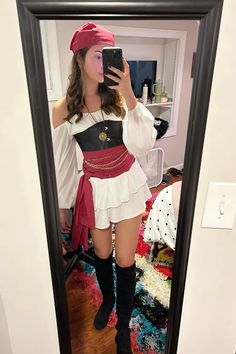 a woman taking a selfie in a mirror wearing a pirate costume and holding a cell phone