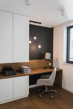 an office with white cabinets and wooden flooring in the corner, along with a desk that has a phone on it