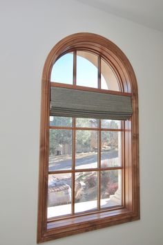 an arched window with blinds on the outside