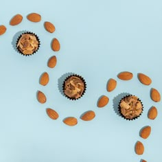 several cupcakes with nuts scattered around them on a light blue background, top view