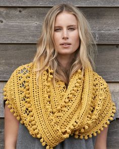 a woman wearing a yellow crocheted shawl