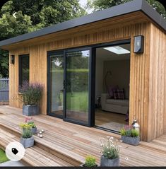 a wooden deck with potted plants on it and a couch in the back ground