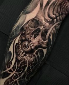 a man's arm with an octopus and skull tattoo on it