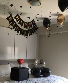 a bedroom decorated with balloons and streamers for a happy birthday party on the bed