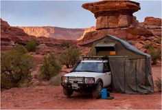 an suv parked in front of a rock formation