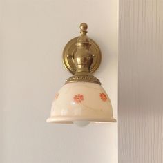 a light that is on the side of a wall next to a white wall with wood paneling