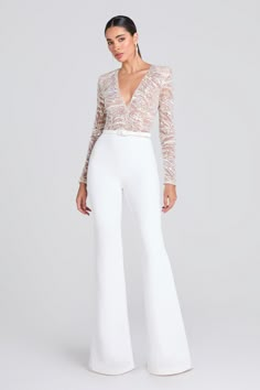 a woman in white pants and lace top