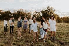 a group of people standing on top of a grass covered field next to each other