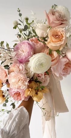 a woman holding a bouquet of flowers in her hand