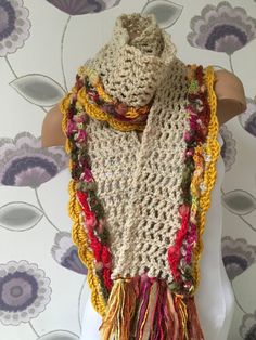 a crocheted scarf with multicolored fringes on a mannequin